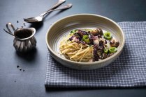 Espaguetis con radicchio frito, champiñones y pimientos - foto de stock