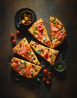 Una pizza cubierta con salami, tomates y aceitunas - foto de stock