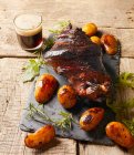 Knusprige Schweinshaxe mit Ofenkartoffeln und Schwarzbier — Stockfoto