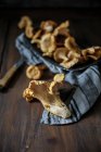 Fresh chanterelle mushrooms on a cloth and on a wooden table — Stock Photo