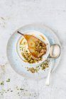 Pistaches, granola et poire vanille cuite au four demi dans un bol — Photo de stock
