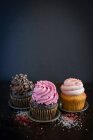 Three different cupcakes on dark background — Foto stock