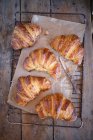 Croissant appena sfornati su sfondo rustico — Foto stock