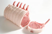 Сырые свиные ребра с ножом и вилкой на белом фоне — стоковое фото