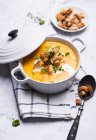 Carrot and parsnip soup with croutons, pine nuts and herbs — Stock Photo