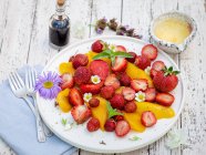 Ensalada de fresa de mango en mesa rústica - foto de stock