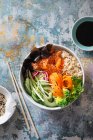 Sushi-Schüssel mit Lachs, braunem Sushi-Reis, Nori Nori, Gurken, Rettich, Karotten und Frühlingszwiebeln — Stockfoto
