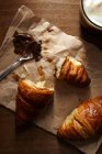 Croissant fresco con crema di nocciole e caffè a colazione — Foto stock