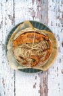 Pane di lievito naturale legato con spago su uno sfondo rustico — Foto stock