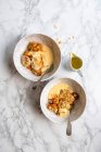 Abricot et amandes émiettent desserts dans des bols de service avec crème anglaise — Photo de stock