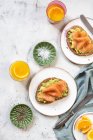 Шматочки хліба з авокадо і копченим лососем на сніданок — стокове фото