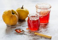 Quince Jelly in jars with fresh Quinces and spoon — Stock Photo