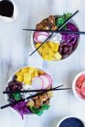 Poke bowl végétalien avec riz basmati, mangue, tofu frit, chou violet, radis, olives, gingembre mariné et sésame noir — Photo de stock