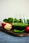 Green smoothie of apple, baby spinach, cucumber, chia seeds on concrete background — Stock Photo