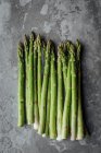 Green asparagus on cement background — Foto stock