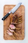 Rack of lamb on a cutting board with a knife — Stock Photo