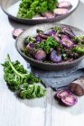 Baked purple potatoes with kale — Stock Photo