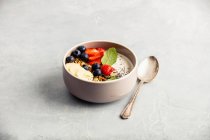 Smoothie bowl with granola, fresh berries, banana, yogurt, chia seeds and mint leaves — Stock Photo