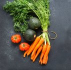 Cenouras, tomates e abobrinha sobre fundo preto — Fotografia de Stock
