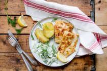 Filé de peixe empanado com batatas e salada de pepino — Fotografia de Stock