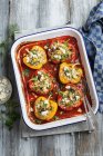 Peppers stuffed with rice, feta, mushrooms, dill and parsley in tomato sauce with feta cheese — Stock Photo
