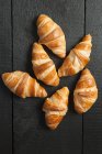 Nahaufnahme mehrerer Croissants auf schwarzem Holz — Stockfoto