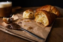 Croissant fresco con crema de avellana y café para el desayuno - foto de stock