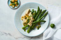 Салат со спаржей и овощами на белой тарелке — стоковое фото