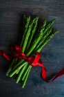 Organic food concept with asparagus and red ribbon — Stock Photo