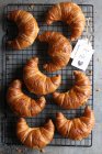 Homemade croissants on a cooling rack with jam — Stock Photo
