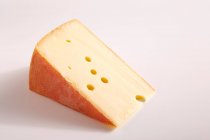 Trozo grande de queso en la superficie blanca - foto de stock