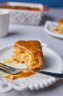 Half eaten slice of Tres Leches cake, covered with caramel sauce and sprinkled with sea salt — Stock Photo