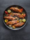 Grilled chicken legs with spices and herbs on a black background. top view. — Stock Photo