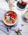 Muesli with almond yogurt and fresh berries, with matcha tea — Stock Photo