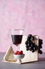 Rotwein, Trauben, Käse und frische Himbeeren — Stockfoto
