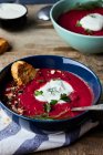 Schüssel Rote-Bete-Suppe mit Kokosmilch und saurer Sahne, garniert mit Petersilie und Dill — Stockfoto