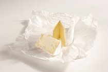 Французский мягкий сыр с белой плесенью в бумажной упаковке — стоковое фото