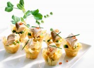 Filo pastry bowls with scrambled eggs, smoked eel, peas and chili — Foto stock