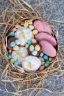 Biscoitos de Páscoa decorados com esmalte rosa e cenouras, mini ovos de chocolate — Fotografia de Stock