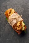 Baguette sandwich with bacon, chedder cheese, mustard, lettuce and vegetables — Stock Photo