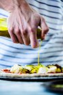 Pürieren von Olivenöl auf Pizza mit Zucchini, Mozzarella und Tomatensauce — Stockfoto
