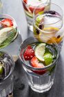 Vasos de bebidas llenas de fruta, menta y jengibre - foto de stock