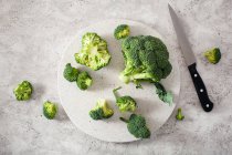 Frischer Brokkoli auf grauem Hintergrund, Draufsicht — Stockfoto