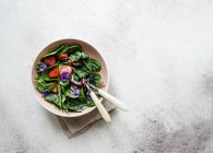 Insalata estiva fresca di spinaci, fragole, cipolle con aceto balsamico e fiori commestibili — Foto stock