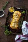 Колбасный штрудель с карамелизированным луком, смешанными травами, горчицей, маком и сушеными помидорами — стоковое фото