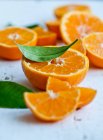 Oranges with leaves, whole, halved and slices — Stock Photo