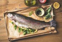 Salmon trout with herbs and lemons — Stock Photo