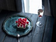 Star shaped ricotta cake with raspberries and glass of champagne — Stock Photo