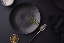 Black dinner setting - empty plates on dark background — Stock Photo