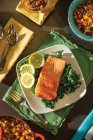 Steelhead trout on bed of lettuce with lemon slices — Stock Photo
